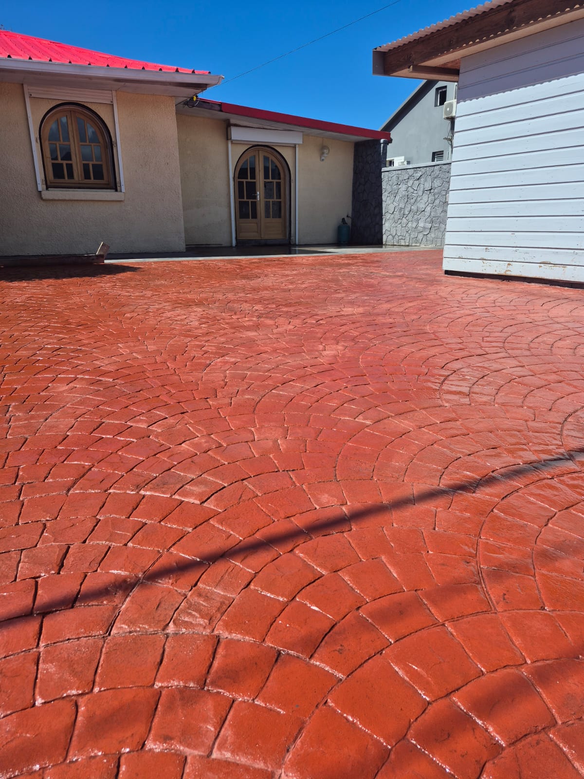 Cour en béton imprimé rouge — motif cobblestone